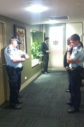 Police wait to escort councillor Nicole Johnston from the Brisbane City Council chambers.