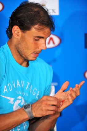 Rafael Nadal shows the blisters on his hand during a media conference after he won his fourth-round match against Kei Nishikori on Monday.