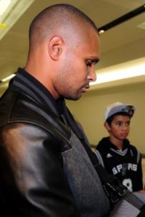Patty Mills signs an autograph for Alyssa Seden,12, of Stirling, at Canberra Airport.
