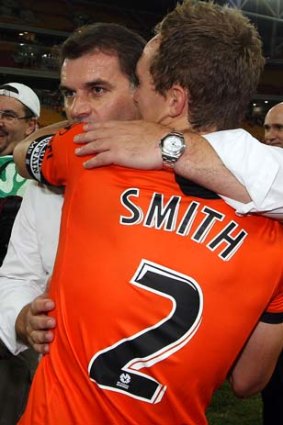 Roar emotion: Ange Postecoglou embraces Brisbane's Matt Smith after last year's A-League grand final.