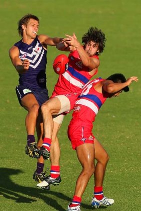 Bulldog Easton Wood finds himself sandwiched between his teammate Lin Jong (right) and Matt De Boer of the Dockers (left) during the NAB Cup match on Saturday.