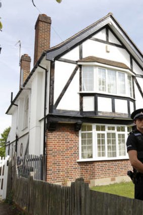 Home and away ... a police officer guards the Surrey house believed to be the British home of a family killed in France.