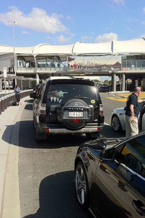 Travellers wait to be picked up at Brisbane Domestic Airport.