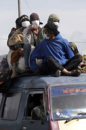 Escape . . . evacuated residents ride on the top of a van.