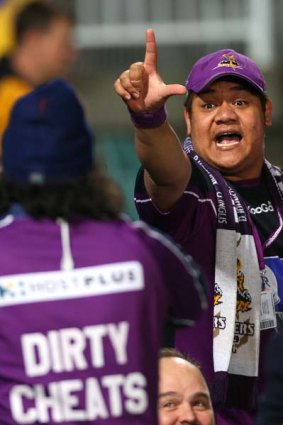 A Storm fan shows his support as an Eels fan wears a "dirty cheats" jumper in Storm colours.