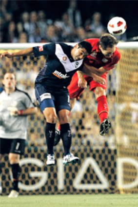 Melbourne Victory’s Carlos Hernandez contests the ball with Adelaide’s Adam Hughes last night.