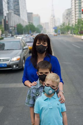 Under wraps: Kristen McAnulty and sons Jacob and Ethan out on a day when the air quality is classified "very unhealthy".