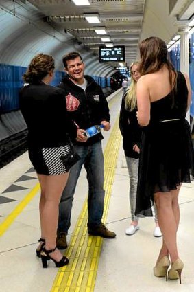 Volunteer Adam Brophy and Salvos worker Tateum Murphy (rear) talk with two women at Parliament Station on Friday.