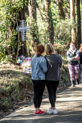 Mourners pay their respects at the scene.