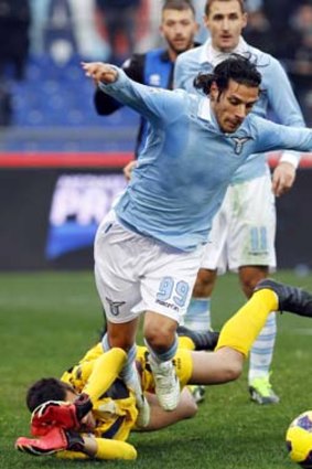 Lazio's Sergio Floccari and Atalanta goalkeeper Andrea Consigli fight for the ball.