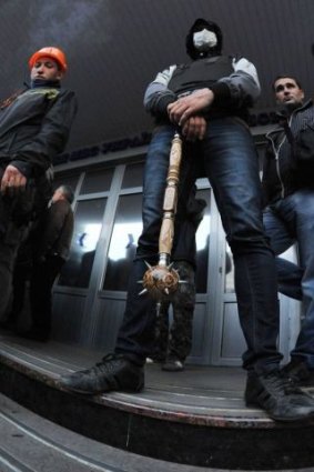 Pro-Russian militiants stand guard after storming the regional police building in Luhansk.