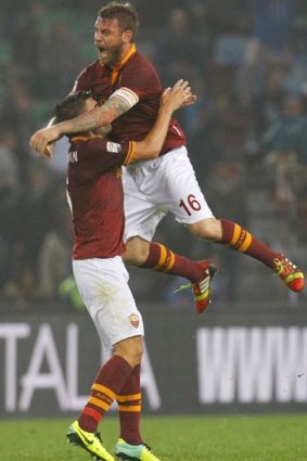 Roma's Daniele De Rossi (top) celebrates the win with Kevin Strootman.