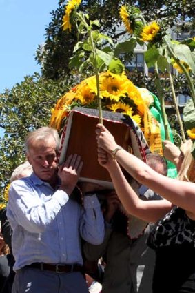 Farewell ... former students form a sunflower guard of honour for his casket.