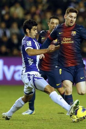 Lionel Messi (right) vies with Valladolid's midfielder Oscar Gonzalez during the Spanish league match in Valladolid.