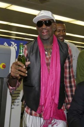 Former NBA player Dennis Rodman holds a bottle of beer as he arrives at the Beijing Capital International Airport to leave for Pyongyang in January.