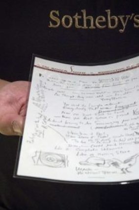 A Sotheby's employee shows the handwritten lyrics for Bob Dylan's <i>Like a Rolling Stone</i> song that is up for auction.