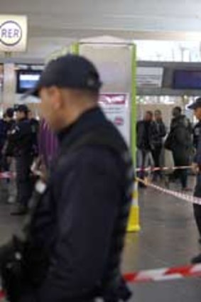 Police officers stand at the site where a man armed with a box cutter attacked a French soldier patrolling a subway station of Paris' business district, stabbing him in the neck.