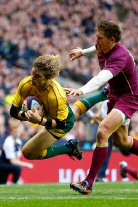 Slippery ... Wallabies winger Nick Cummins eludes Toby Flood of England to score a try at Twickenham on Saturday.