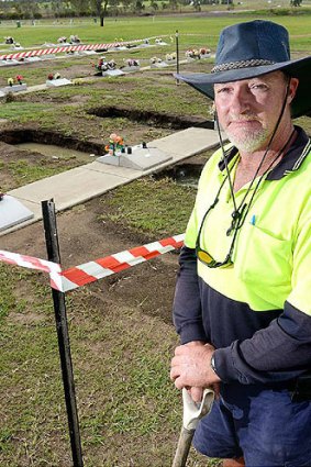 Warrill Park Cemetery grounds supervisor Rick Nice at a damaged grave site.