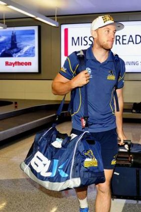 Brumbies player Jesse Mogg collects his luggage.
