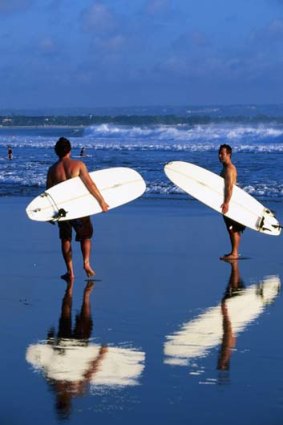 Surfers on shore at Legian beach.