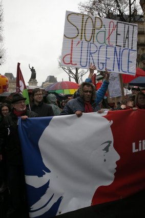 A protester holds a banner reading "Stop the state of emergency" in Paris.