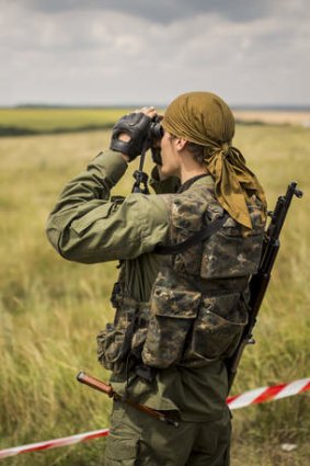 Russian separatists deny responsibility for the missile: A pro-Russia rebel surveys the area around the MH17 wreckage.