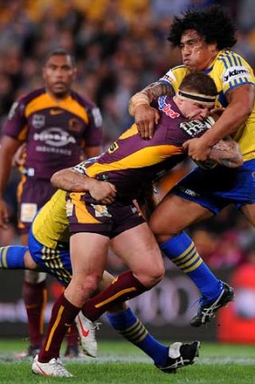 Crunch time &#8230; Bronco John Maguire runs into a brick wall in the form of Fuifui Moimoi at Suncorp Stadium last night where the Eels stunned the home side 42-22.