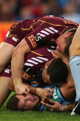 Brent Tate of the Maroons punches Greg Bird of the Blues during game three of the 2012 State of Origin series.