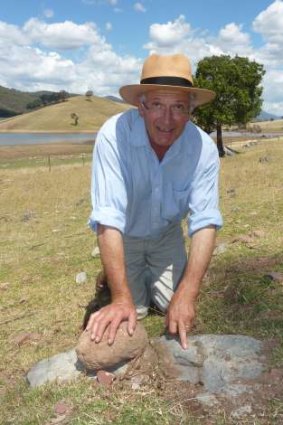 Ian Cathles points out at a piece of bone from a Placoderm (armour plated fish) encased and preserved in the sediment on his Wee Jasper property, Cooradigbee - the location of his popular fossil tours.