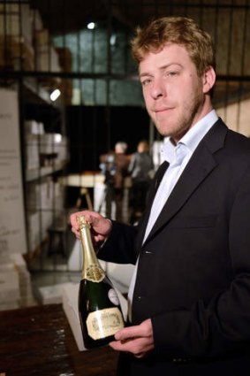 Wine expert Ambroise de Montigny presents a bottle of Champagne Kug 1985 from the Elysee Palace cellar which will be sold during an auction on May 30, 2013 in Issy-les-Moulineaux, outside Paris.