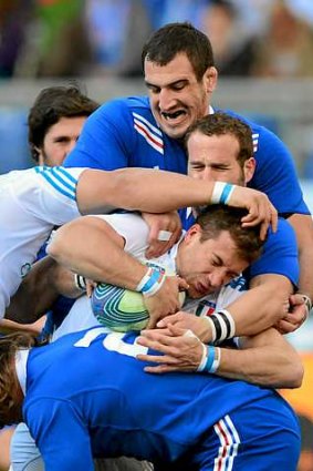 Italy's centre Tommaso Benvenuti is tackled by France's fly-half Frederic Michalak and lock Yoann Maestri.