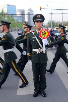 A guard stops traffic on the way to the US embassy compound in Beijing after reports of Chen Guangchen's escape from detention.