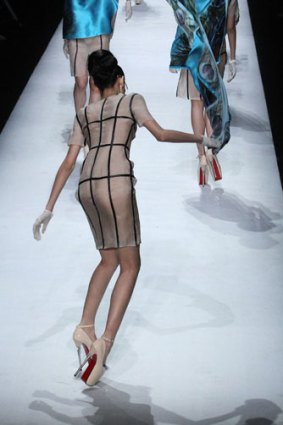 A model falls over on the runway at SECCRY Hu Sheguang Collection 2014 Show during Mercedes-Benz China Fashion Week.