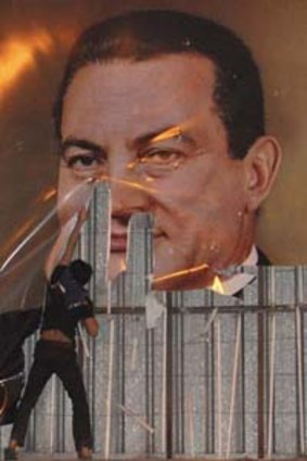 A demonstrator defaces a poster of President Hosni Mubarak in Alexandria, Egypt.
