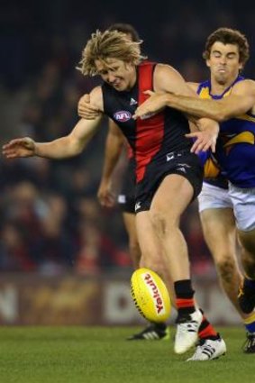 Dyson Heppell gets a kick away as Eagle Jamie Cripps tries to prevent him disposing of the ball.