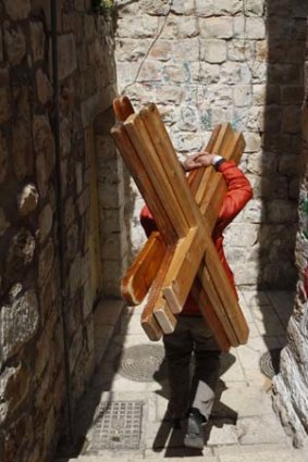 In demand ... Mazen Khanan, a Muslim who hires crosses to visiting Christians, carries four to the First Station of the Cross.
