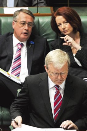 Watch your back … overlooked by Wayne Swan and Julia Gillard, then PM Kevin Rudd reads his notes during Question Time at Parliament House on June 21, 2010.
