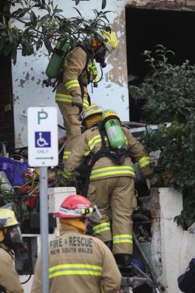 Hampered by piles of rubbish: firefighters at the scene.