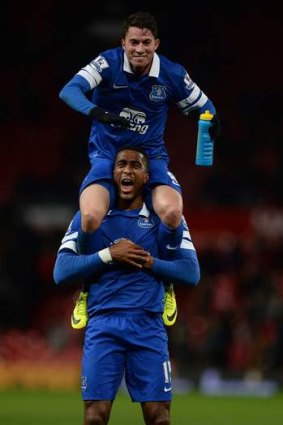 Everton's Sylvain Distin (lower) and Bryan Oviedo celebrate their victory over Manchester United.