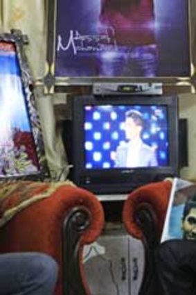 Shadi, the brother of Palestinian singer Mohammad Assaf, watches the final of the <i>Arab Idol</i> competition in southern Gaza Strip.
