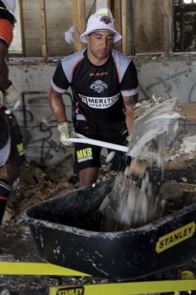 Helping hand ... Wests Tigers star Benji Marshall was part of the clean up effort in Goodna yesterday.