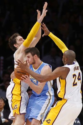 Danilo Gallinari (centre) of the Denver Nuggets passes as he is blocked by Pau Gasol (left) and Kobe Bryant (right) of the Los Angeles Lakers.