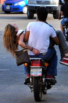 Genesis Carmona is driven away on a motorcycle after she was shot during an anti-government protest.