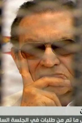 Hosni Mubarak: Ousted Egyptian president sits behind bars during a hearing in his retrial at the police academy in Cairo.