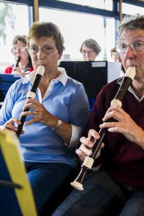 Judie Mackenna and Leslie Harland, members of the Recorder Orchestra, play in the ferry on Lake Burley Griffin yesterday .