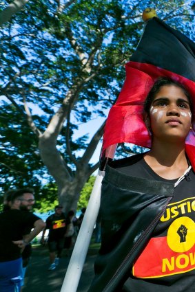13 year old Jenna-Lee Roberts of Doonside flys the Aboriginal flag at the front of the protest. Aborginal Human Rights protest through Circular Quay on December 10, 2016 in Sydney, Australia. 