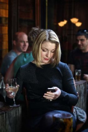 Stacey Brown uses her iPhone dating app at The Bridge Hotel, Richmond.