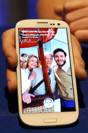 A Facebook employee holds a phone that is running the new "Home" program during an event at Facebook headquarters.