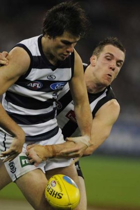 Not much between them. Geelong's Andrew Mackie battles with Collingwood's Dane Swan.